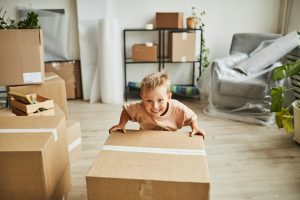 smiling-boy-moving-boxes-in-new-home